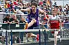 Athlete jumping over a hurdle at a track meet.