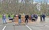 Group of volunteers at a park cleanup event with wheelbarrows and mulch.