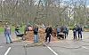 Group of volunteers at a park cleanup event with wheelbarrows and mulch.