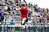 Athlete jumping over a hurdle at a track meet.