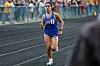 Female athlete running on a track in a blue uniform.
