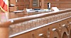 Courtroom interior with wooden details and an American flag.