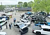 Vehicles displayed at a community event with attendees interacting.