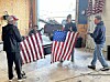 Volunteers handling American flags in a workshop.