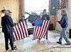 Volunteers handling American flags in a workshop.