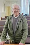 Elderly man smiling in a community space.