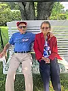 Elderly couple on a swing in a garden.
