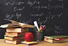 Books, an apple, and stationery on a desk with a chalkboard.