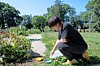 Gardener kneeling in a community garden.