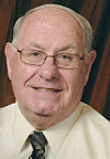 Close-up portrait of an older man with glasses.