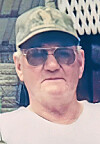 Older man with sunglasses and camouflage cap.