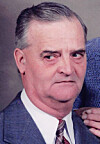 Close-up of a man in a suit with a serious expression.