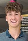 Smiling young man with braces in a casual setting.