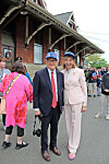 Two individuals in formal attire pose together at an outdoor event.