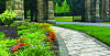 Stone pathway lined with flowers in a garden setting.
