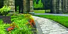 Stone pathway lined with flowers in a garden setting.