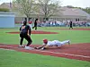 Baseball player sliding into base with another player nearby.