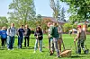 Group of people planting a tree in a park.