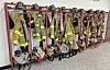 Firefighter gear hanging on racks in a fire station.