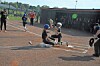 Youth softball players at home plate during a game.