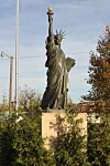 Statue of Liberty replica in a park setting.