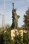 Statue of Liberty replica in a park setting.
