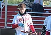 Baseball player in a white and red jersey holding a bat.