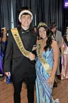 Prom king and queen smiling together at the event.