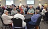 Group of people seated around tables at a community event.