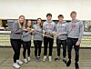 Students holding a trophy in a cafeteria.