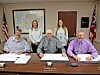 Local government officials seated at a table during a meeting.