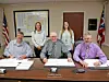 Local government officials seated at a table during a meeting.