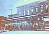 Historic streetcar and crew in front of a building.