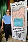 Man next to a banner promoting a railway book.