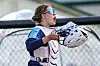 Softball catcher with helmet and gear in action.