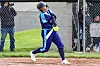 Player in blue uniform swings at a softball.
