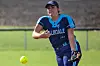Softball player pitching a ball on the field.