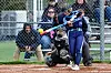 Softball player swinging at a pitch with a catcher behind.
