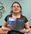 Author holding two editions of 'Morrow' book.