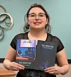 Author holding two editions of 'Morrow' book.