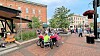 A lively outdoor scene with people socializing in a plaza.