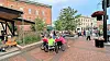 A lively outdoor scene with people socializing in a plaza.