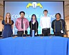 Students at a recognition ceremony with candles on a blue table.