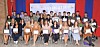 Group of graduates holding certificates at a ceremony.
