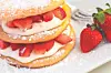 Layered dessert with strawberries and cream on a plate.