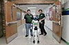 Students with a robot in a school corridor.