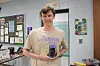 Student holding an award in a classroom