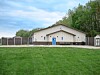 Community building with blue doors and windows in a grassy area.