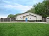 Community building with blue doors and windows in a grassy area.