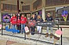 Group of people in red shirts outside an ice cream shop.